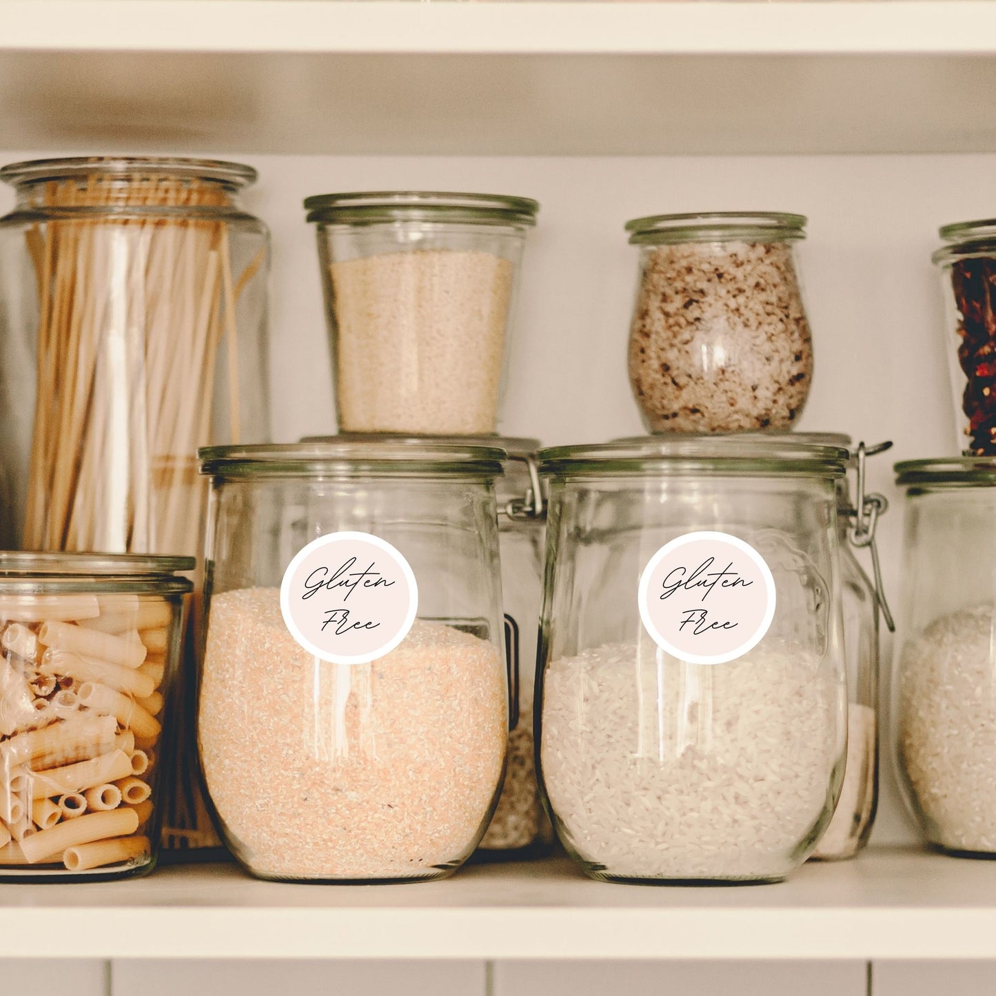 Pastel Gluten Free labels on glass pantry jars filled with pasta, flour, and oats.