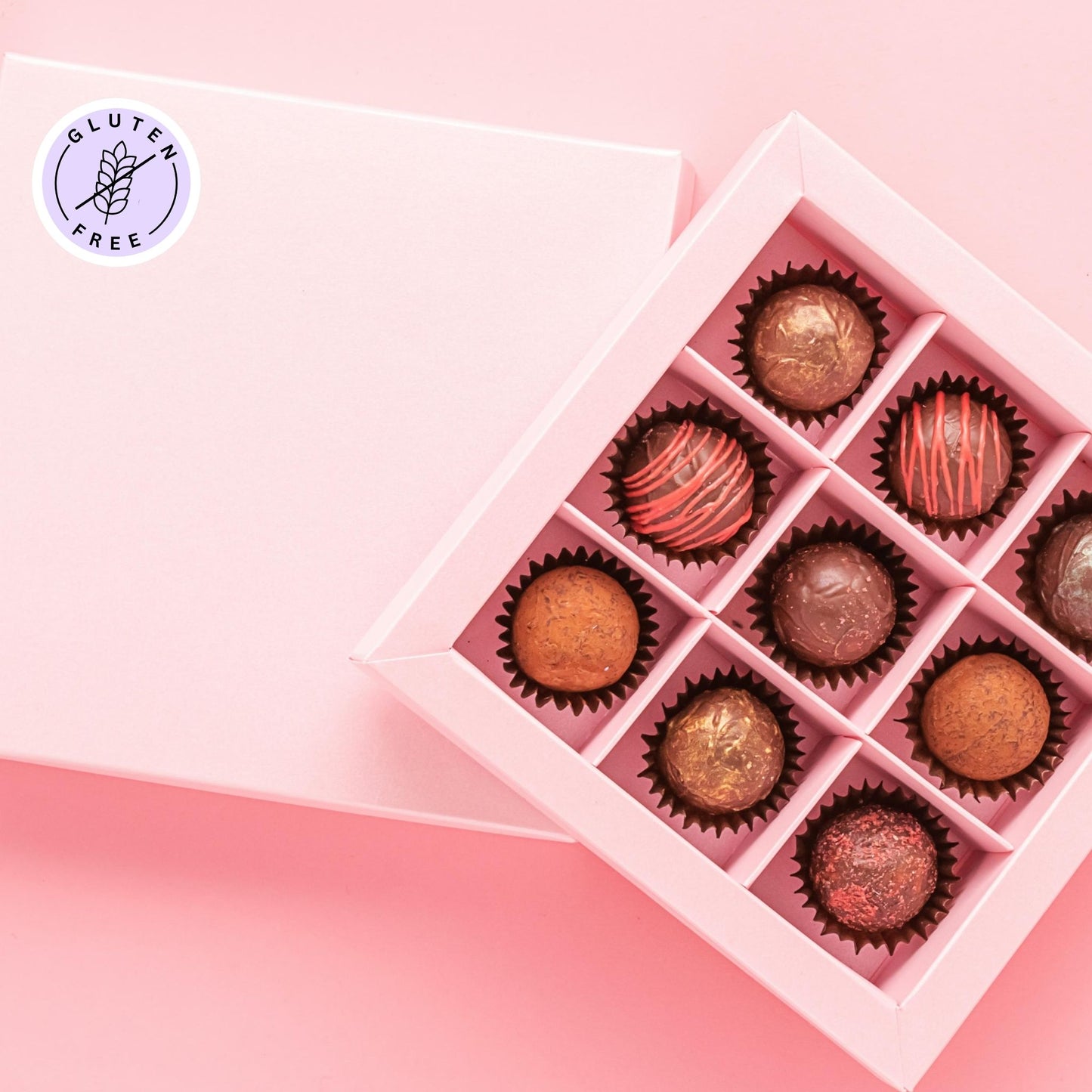 Purple “Gluten Free” labels on a pink box of chocolates.